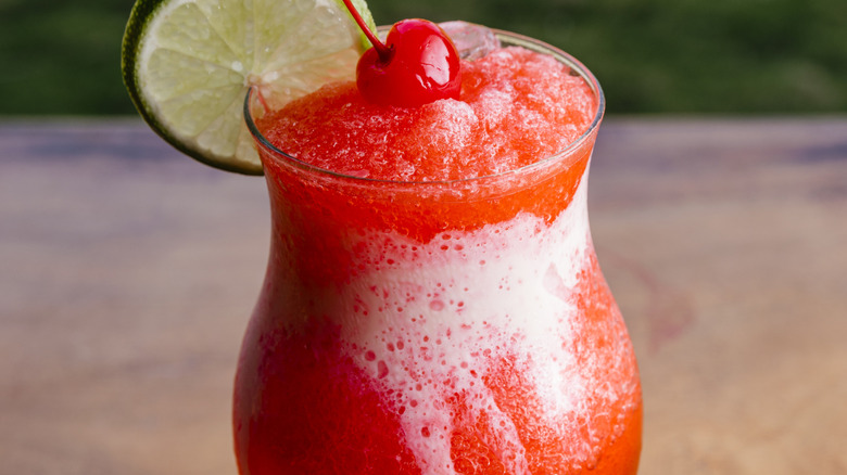 Strawberry daiquiri with lime and cherry garnish