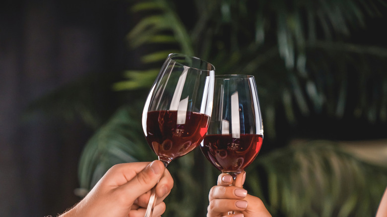 hands toasting with wine glasses with red wine