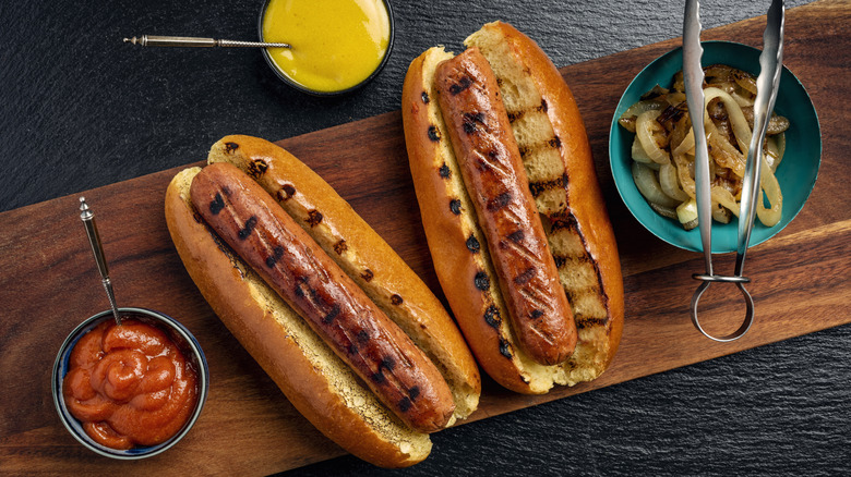 Hot dogs in buns, grilled to perfection with mustard, ketchup and onions