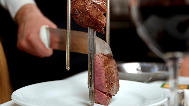 Filet mignon on skewer being carved