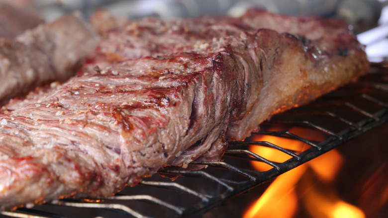 Fraldinha cooking on grill over fire
