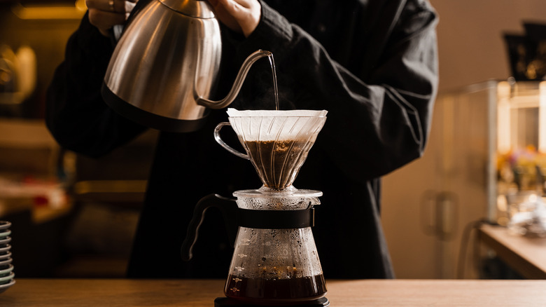 Person making pour over coffee at home