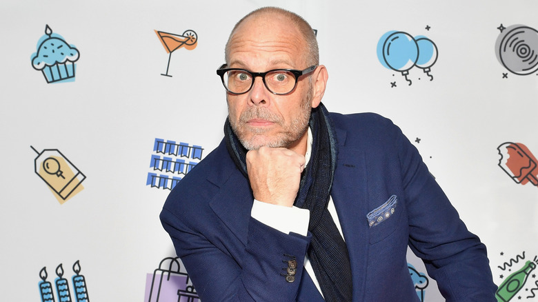 Alton Brown resting his chin on his hand at a Food Network event