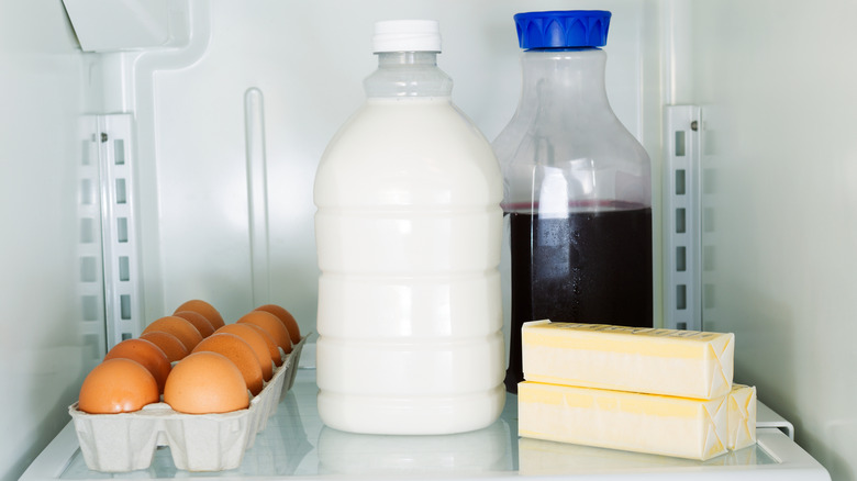 Eggs, milk, juice, and sticks of butter in refrigerator