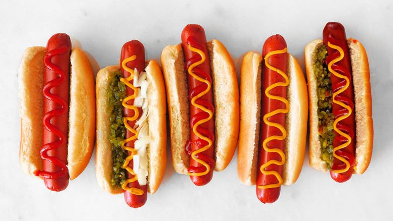 Hot dogs on buns with ketchup, mustard, and relish