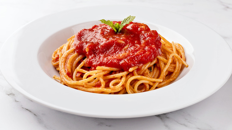 A bowl of spaghetti topped with tomato sauce