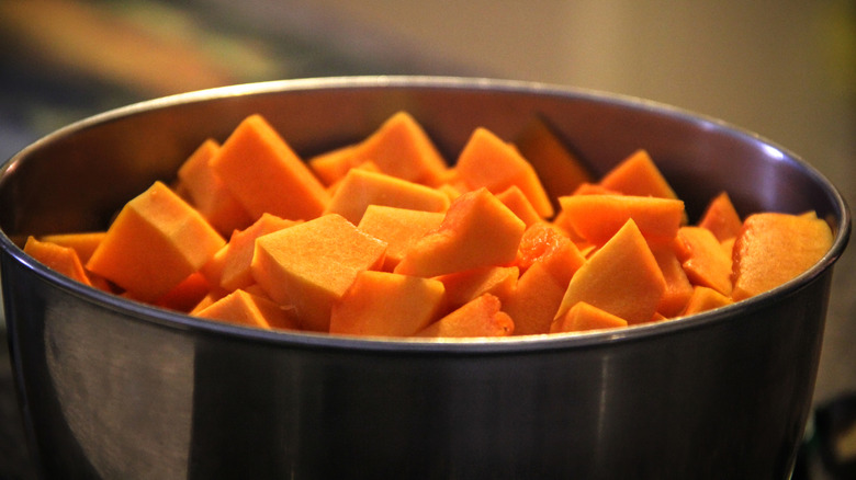 A closeup of diced sweet potatoes in a metal pot