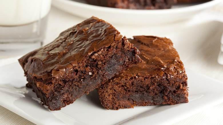 Two fudgy homemade brownies on a white plate
