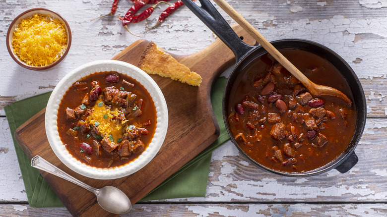 Top view of pot and bowl of beef and bean chili