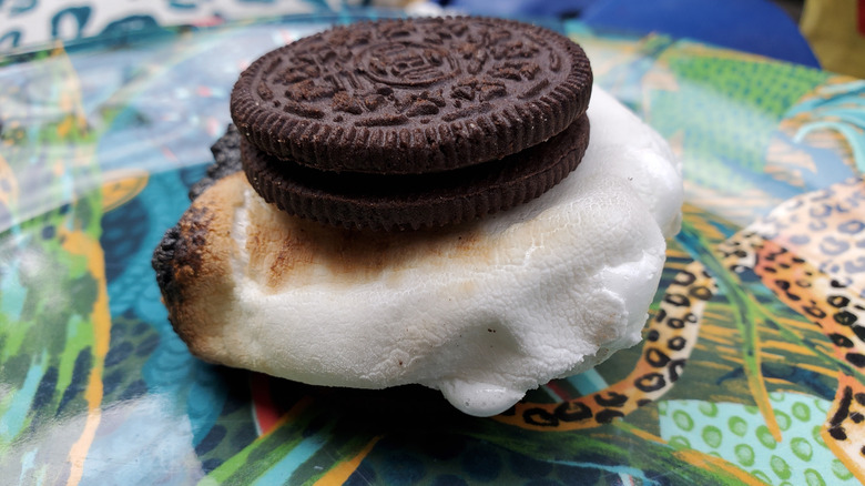 s'more made with Oreos on a jungle-patterned tablecloth