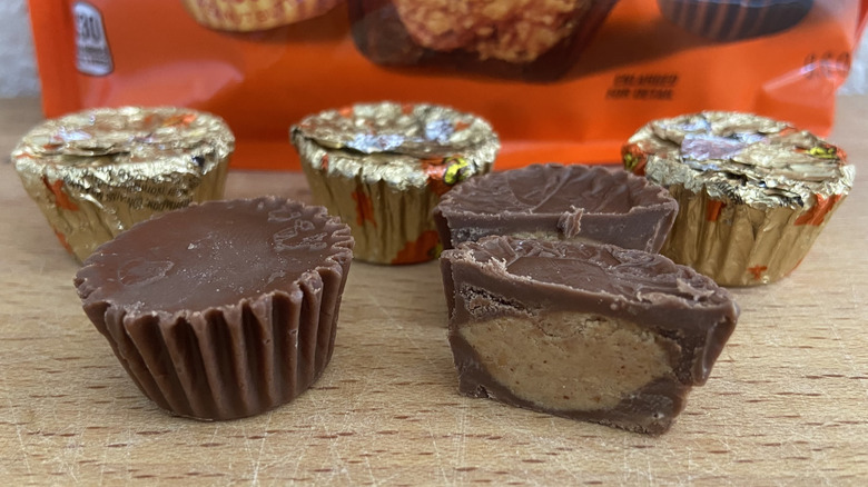 close-up of five Reese's peanut butter cups, one halved