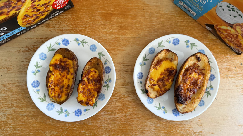 top-down view of two of each potato skin on a small plate beside their boxes