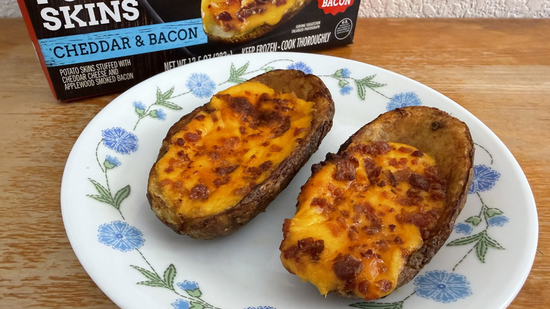 close-up of two TGI Fridays potato skins on a small plate with their box in the background
