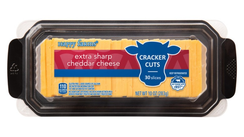 A package of Happy Farms cracker-cut extra sharp cheddar cheese on a white background.