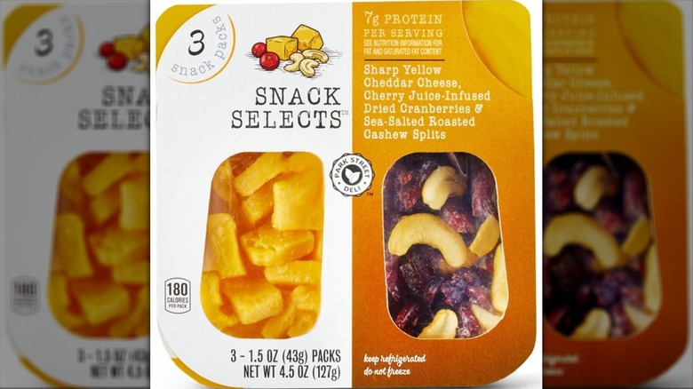 A package of Snack Selects with sharp yellow cheddar, cherry-flavored cranberries, and cashews on a white background.
