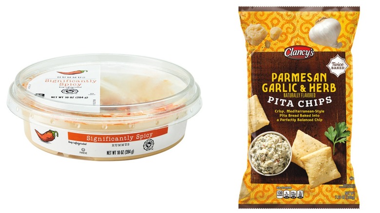 A tub of Park Street Deli spicy hummus and bag of Clancy's parmesan garlic pita chips on a white background.