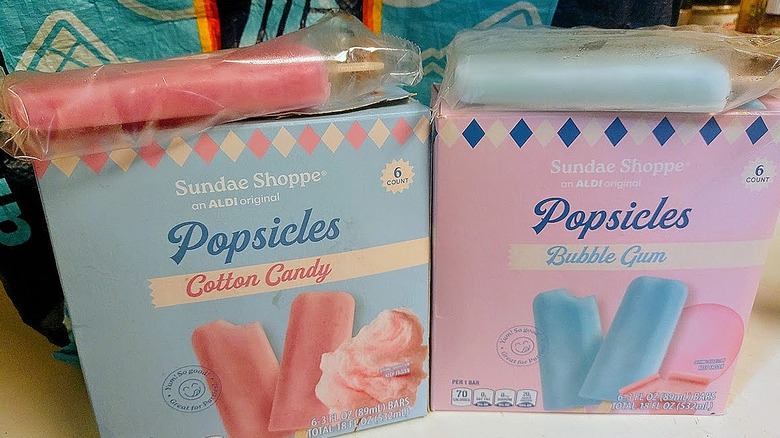 boxes of Sundae Shoppe Cotton Candy and Bubble Gum Popsicles, each with a popsicle on top, in front of a reusable Aldi shopping bag