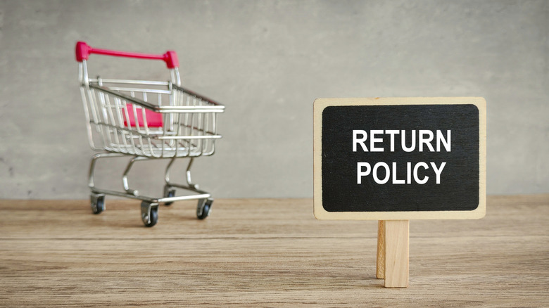 A shopping cart and a "return policy" sign
