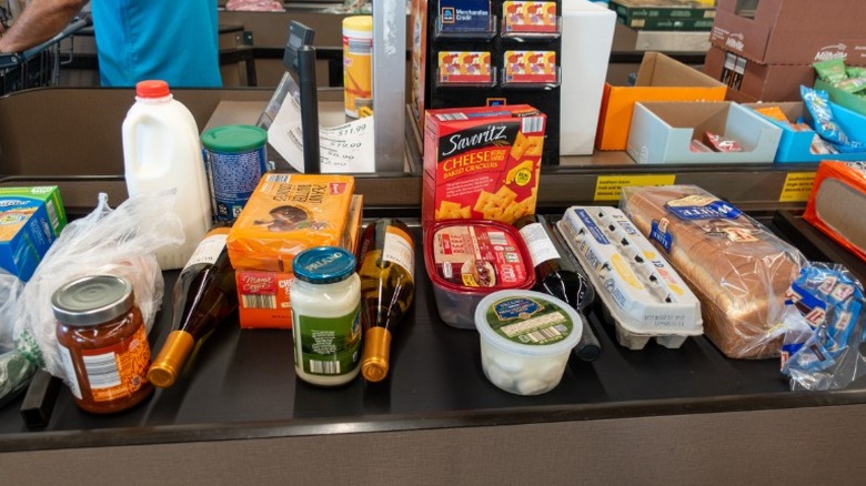 A conveyer belt at a grocery store checkout full of food items
