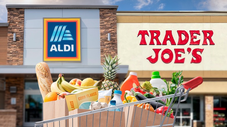 Aldi and Trader Joe's storefronts side-by-side with cart of groceries in foreground
