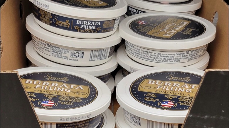 Stacks of Aldi burrata filling stracciatella tubs