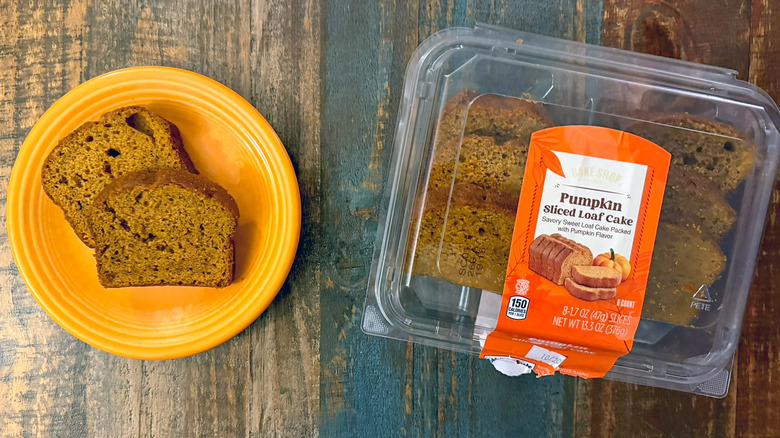 Bake shop Pumpkin loaf cake from Aldi in clamshell packaging next to plate with two slices of loaf