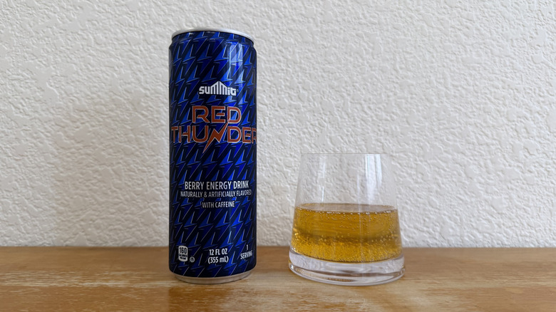 Red Thunder can beside a small, half-full glass