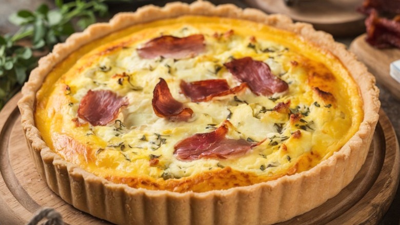 a quiche lorraine on a wooden plate
