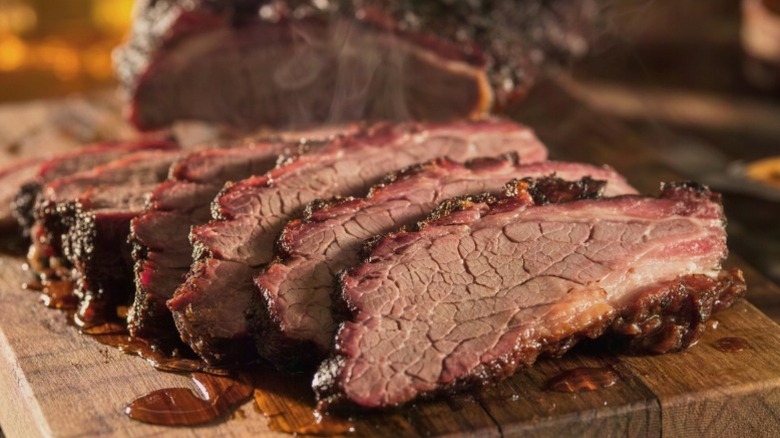 Slices of barbecue brisket on a wooden cutting board.