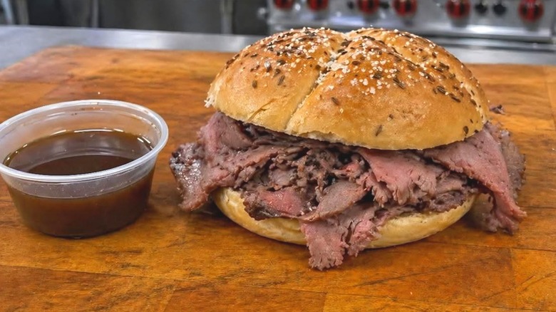 A beef on weck sandwich sits on a cutting board