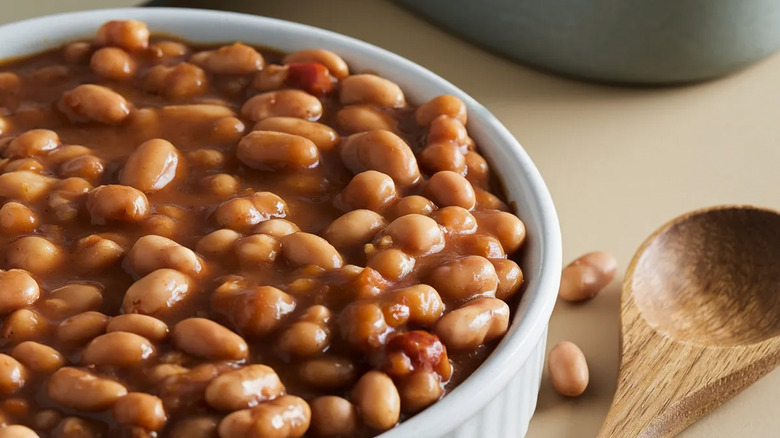 Boston baked beans in a bowl with wooden spoon