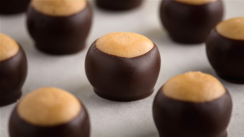 Closeup of evenly spaced buckeye candies on parchment paper