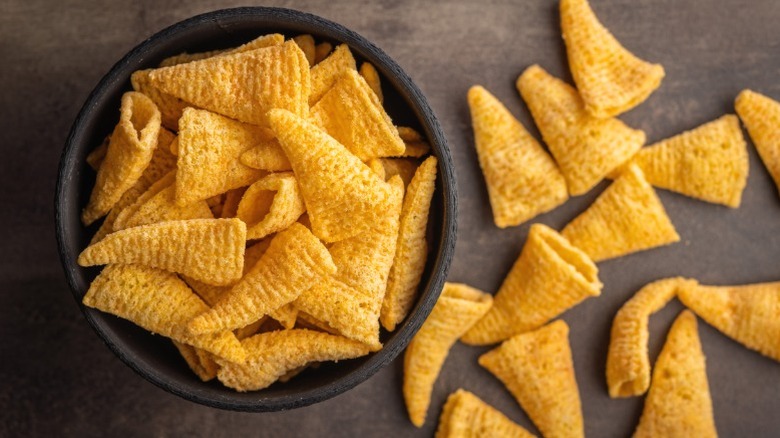 A bowl of Bugles, with others arranged on the table surface.