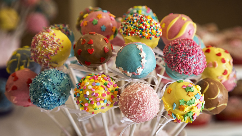 A variety of colorful cake pops sit in a container
