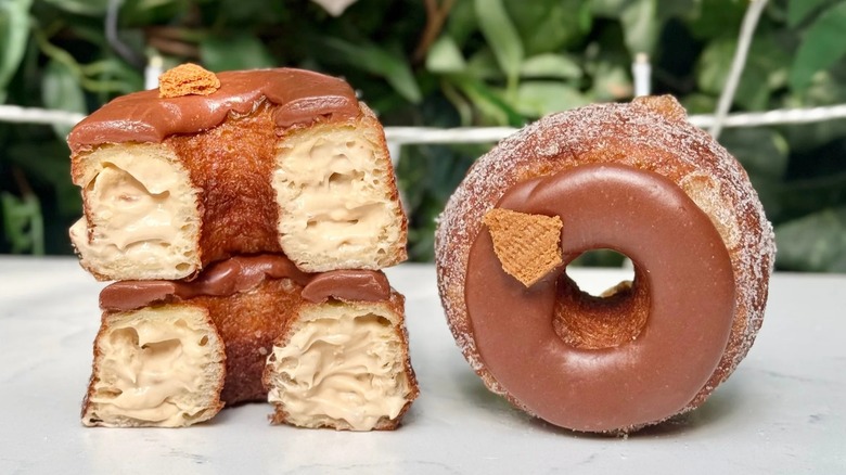 Cronut cut in half stacked on itself next two a chocolate cronut