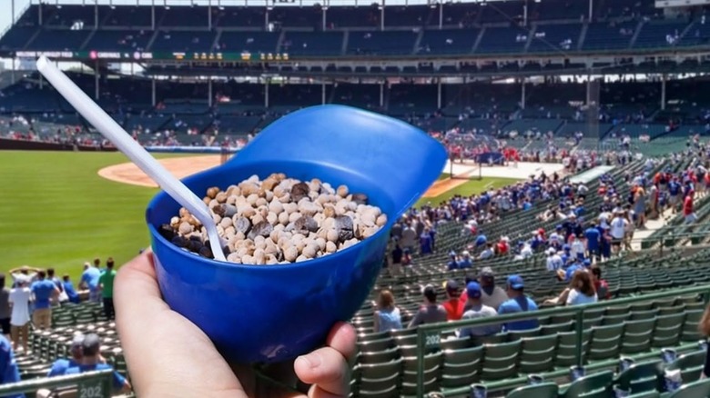 A hand holds out a mini baseball helmet filled with Dippin' Dots