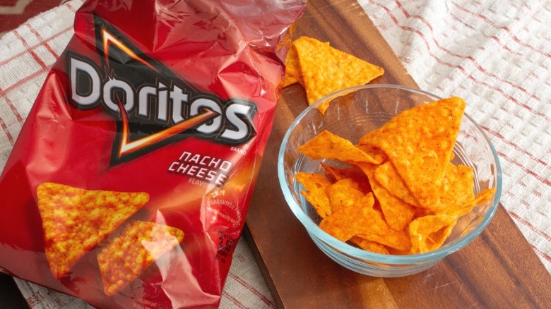A bowl of Nacho Cheese Doritos next to a bag.