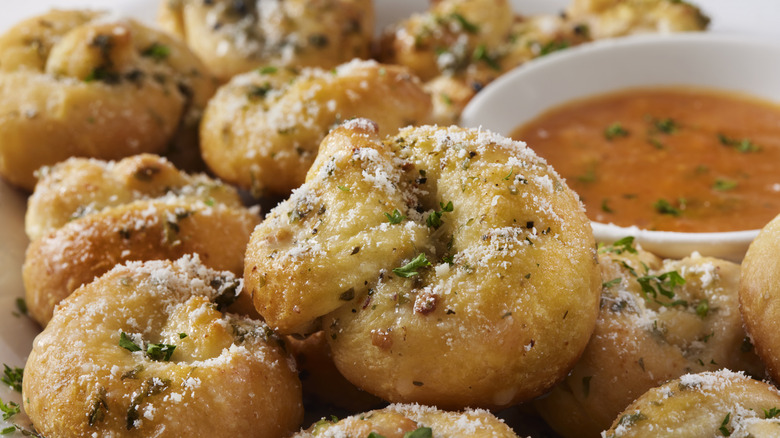 Garlic knots with marinara sauce in the background