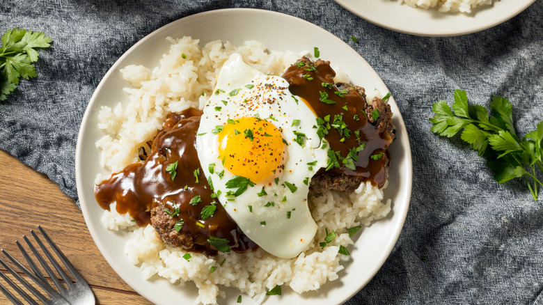 Hawaiian loco moco on a white plate on a gray tablecloth