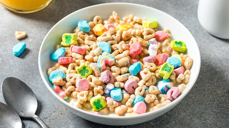Lucky Charms cereal with milk in a white bowl on a gray surface