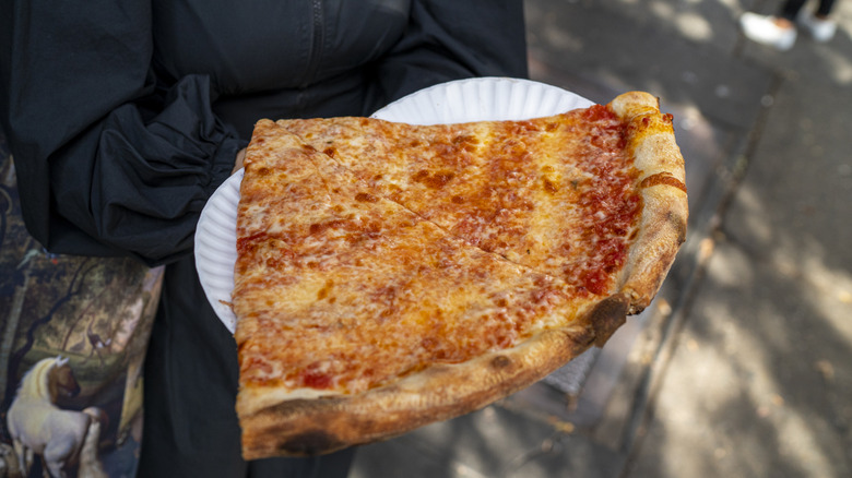 Two slices of pizza on white paper plates