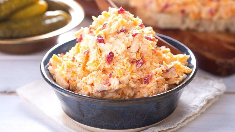 Pimento cheese in a gray ceramic bowl over a cloth napkin