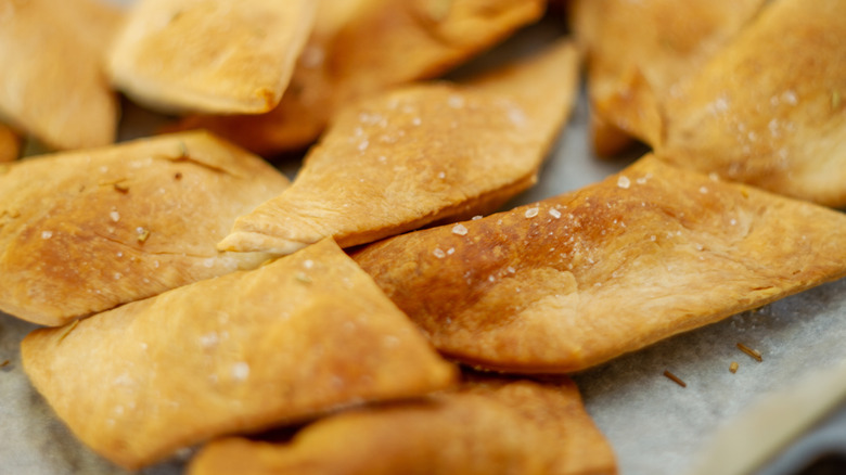 Pita chips are flaked with salt