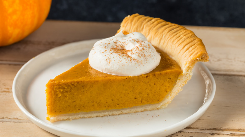 Slice of pumpkin pie with whipped cream