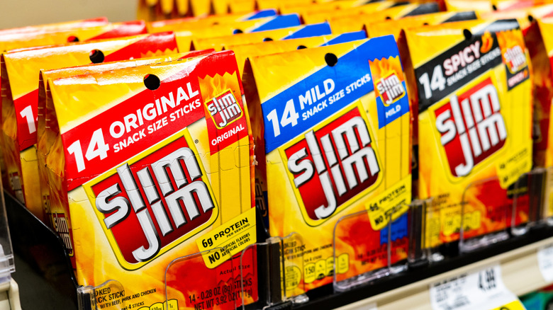 Packages of Slim Jim cured beef sticks on grocery store shelf.