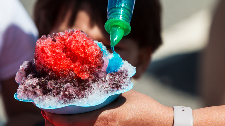 Snow Cone with blue flavor being poured on it
