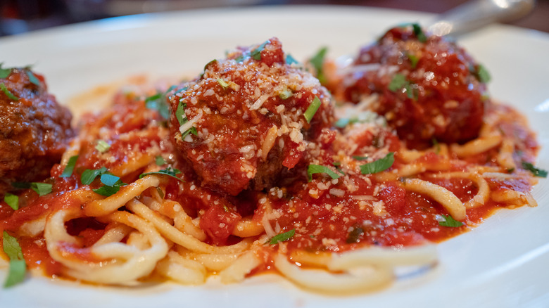 plate of spaghetti and meatballs with parmesan cheese