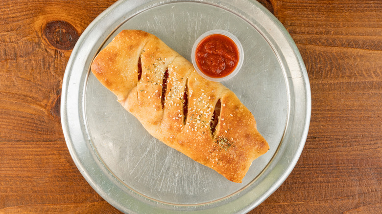 A stromboli sits on a pizza pan