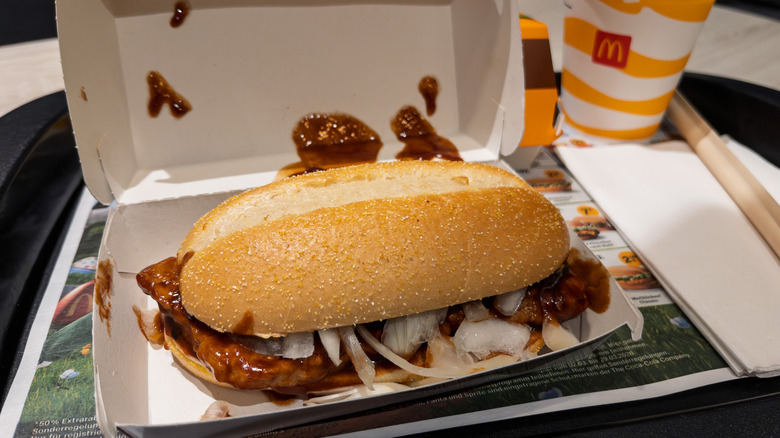 McDonald's McRib sandwich in open box on tray.