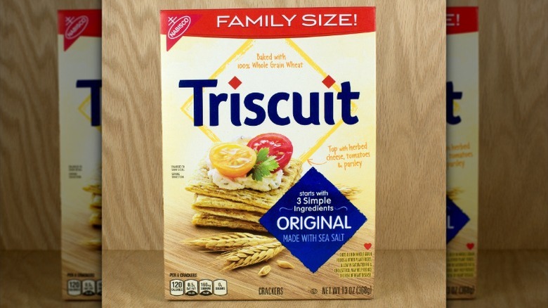large box of original Triscuits standing in front of a wood-paneled wall